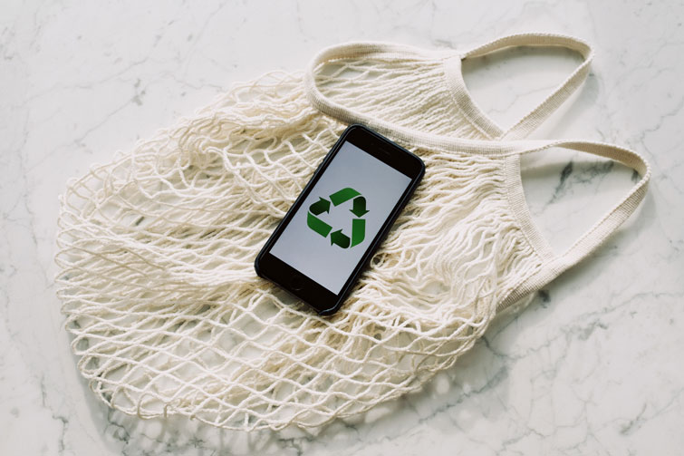 Sac et téléphone portable signifiant le recyclage de vêtements contre bon d’achat