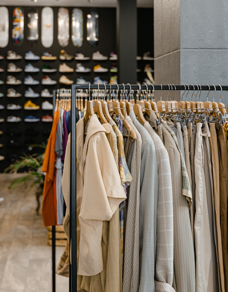 Vue dans un magasin de vêtements avec des chaussures et des skates dans le fond. Image qui illustre l’article sur l’impact de la fast fashion sur l'environnement.